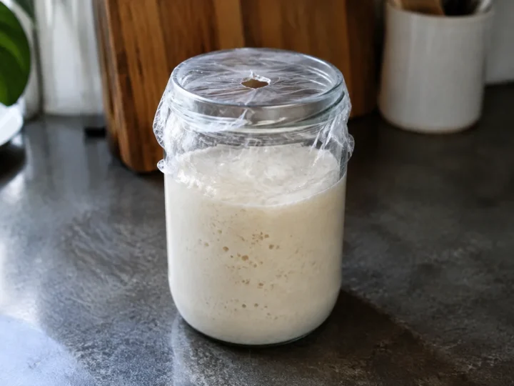 Bocal en verre posé sur comptoir avec film plastique percé