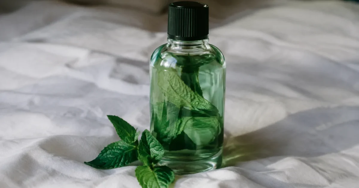 Flacon en verre de menthe posé sur drap blanc