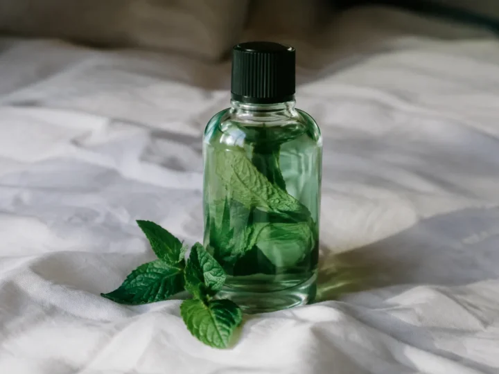 Flacon en verre de menthe posé sur drap blanc