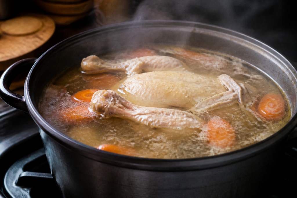 Marmite fumante de bouillon avec poule et carottes