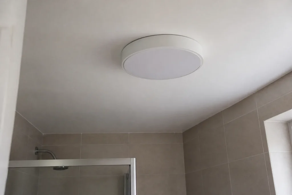 Plafonnier blanc fixe sur plafond de salle de bain